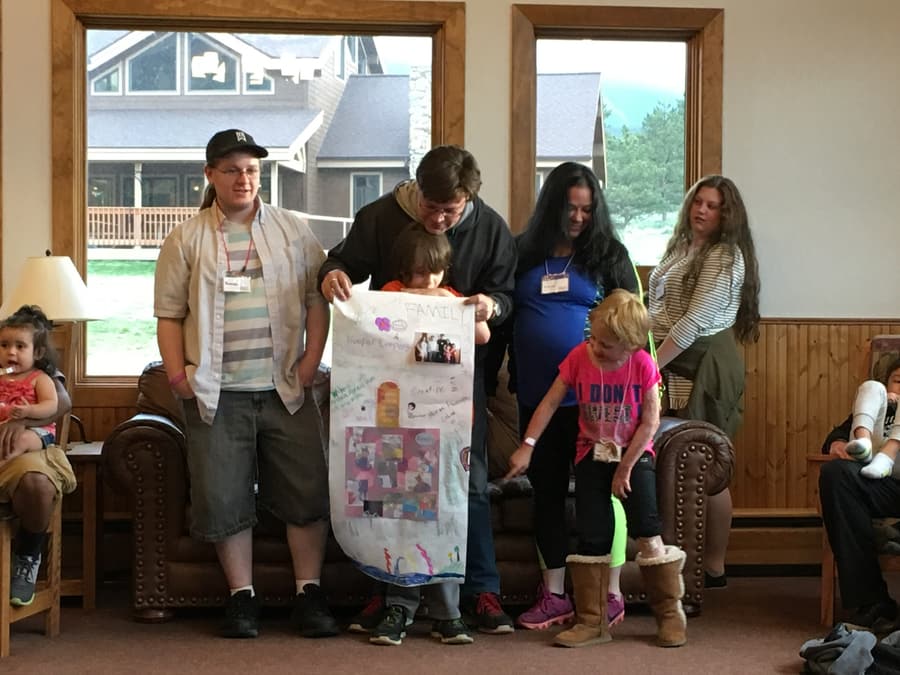 A family presenting a poster they created together at Family Burn Camp