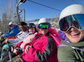 Winter Burn Camp participants smiling together on a chairlift