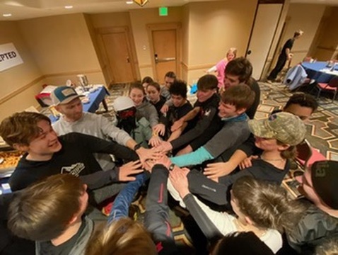 Winter Burn Camp participants joining hands in a team huddle
